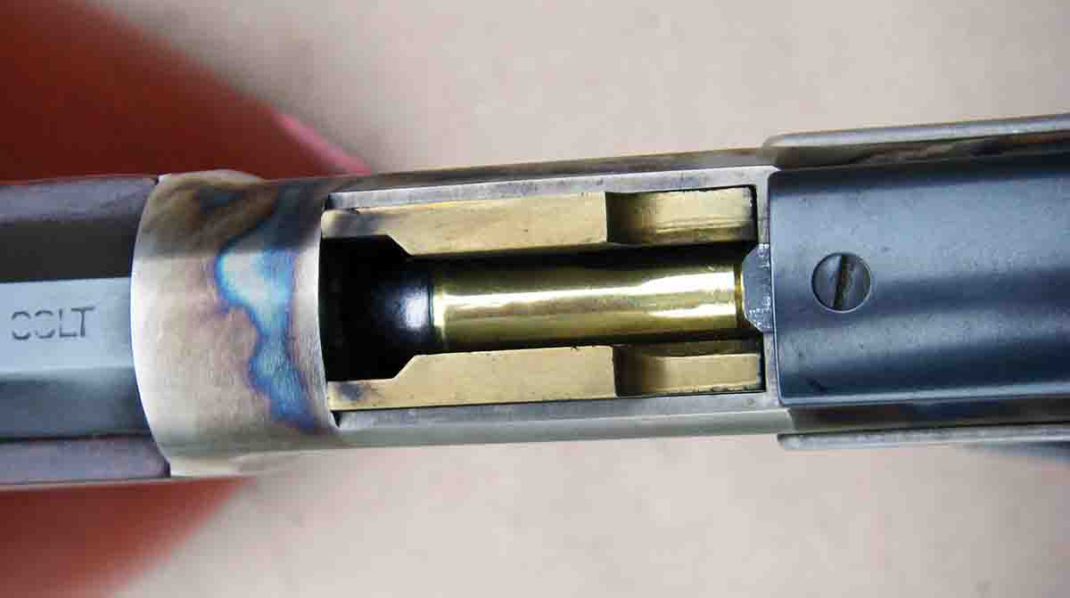 A brass carrier lifts and aligns cartridges with the chamber for direct feeding as the breech is closed.